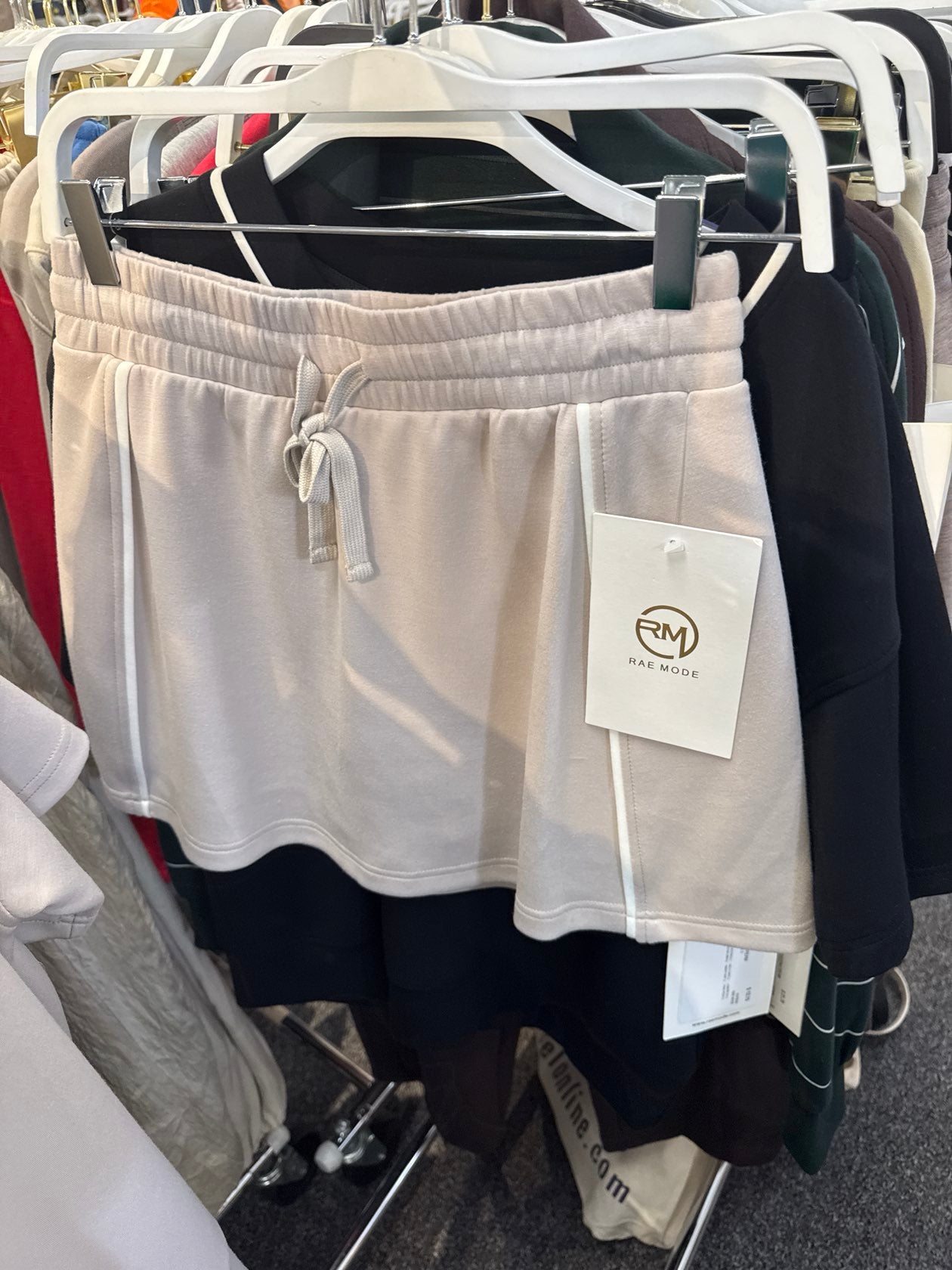 Rae Mode Gwendolyn mocha cream and black color-block drawstring shorts hanging on retail rack.