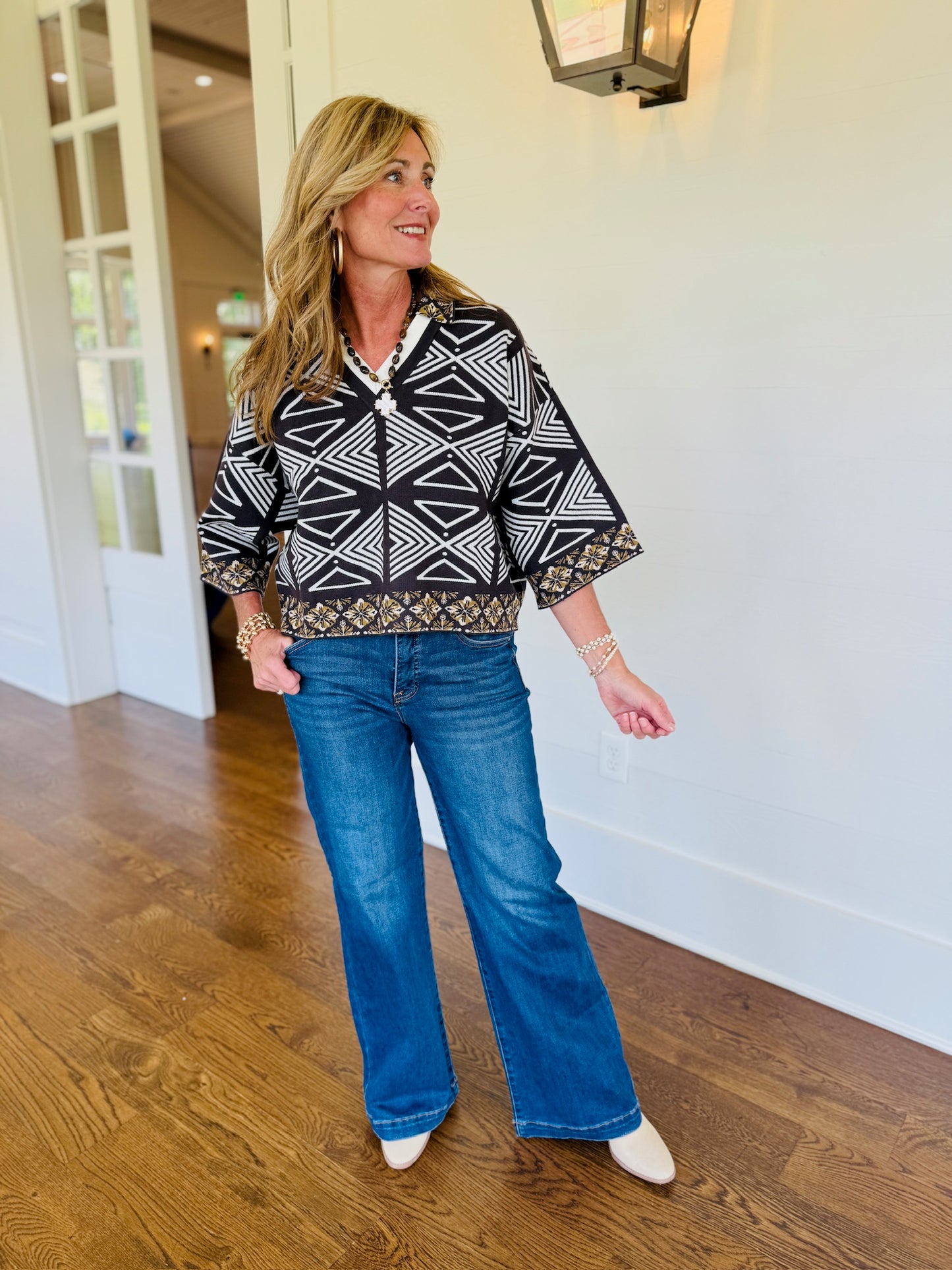 Full-length view of the Rylee flowy geometric print 3/4 sleeve top styled with wide-leg denim