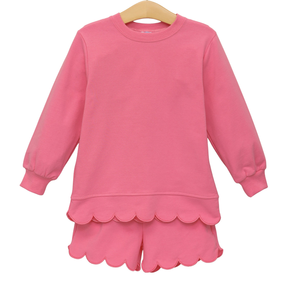 Pink children's long-sleeve sweatshirt and matching shorts set with scalloped hem detailing.