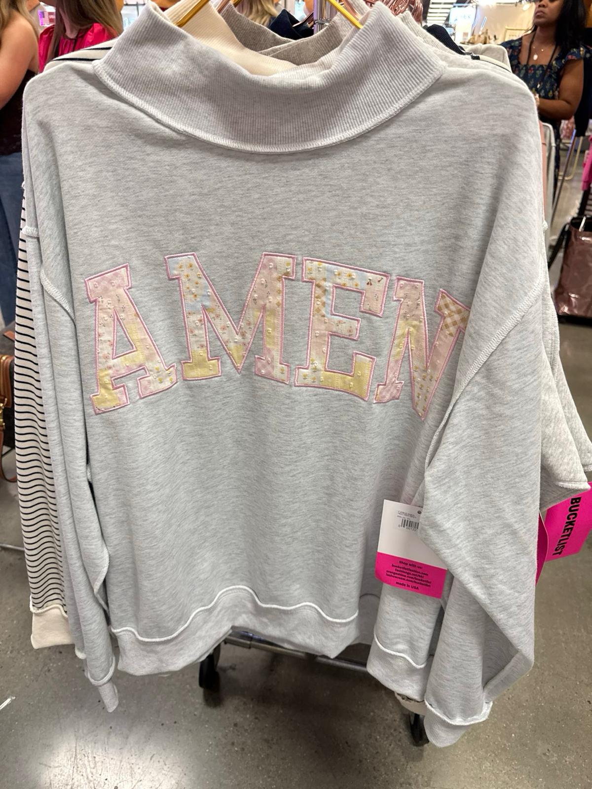 Gray turtleneck sweatshirt with pastel patchwork "AMEN" letter appliqué on front, displayed on hanger.