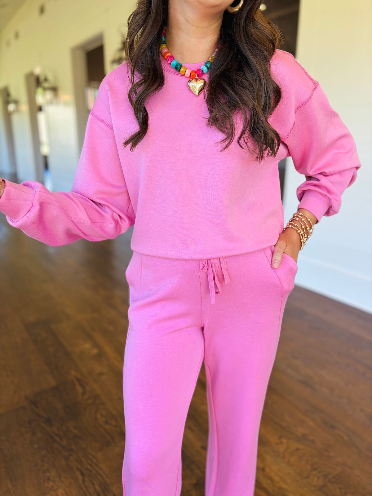 Closer view of the Alora pink lounge sweatshirt showing its crew neckline, dropped shoulders and gathered long sleeves.