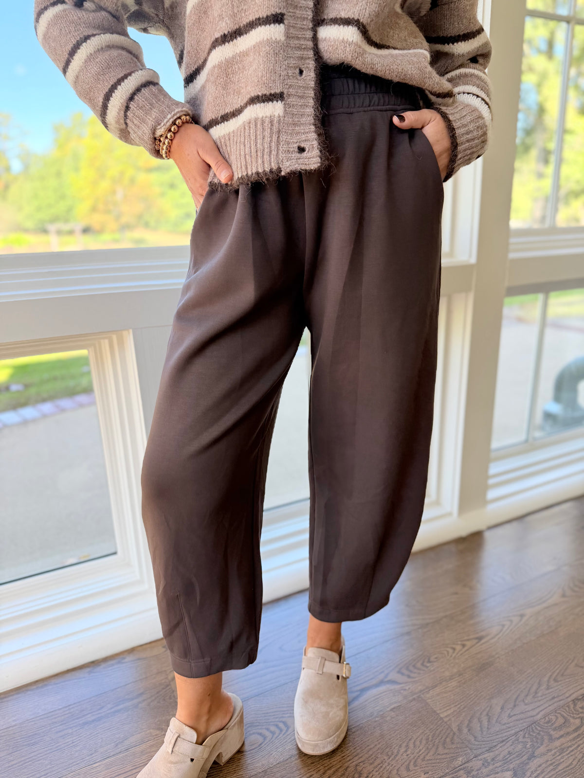 Close-up of the Anastasia espresso lounge pants showing their gathered elastic waistband, side pockets and relaxed tapered legs.