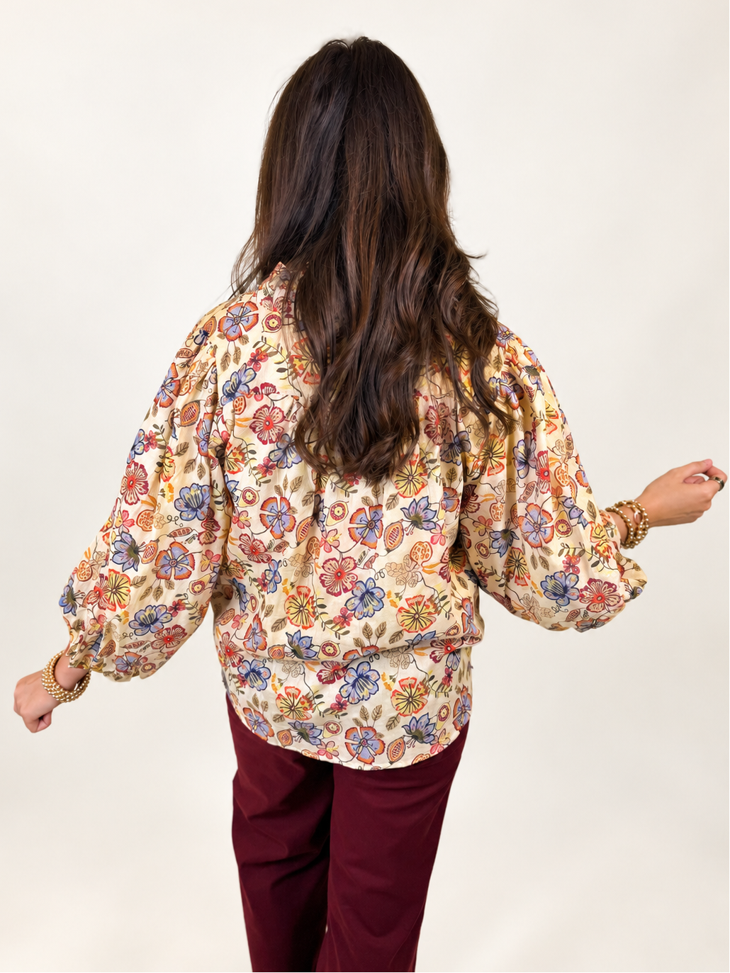 Back view of the Annabelle ivory floral blouse showing its multicolor print and relaxed balloon sleeves.