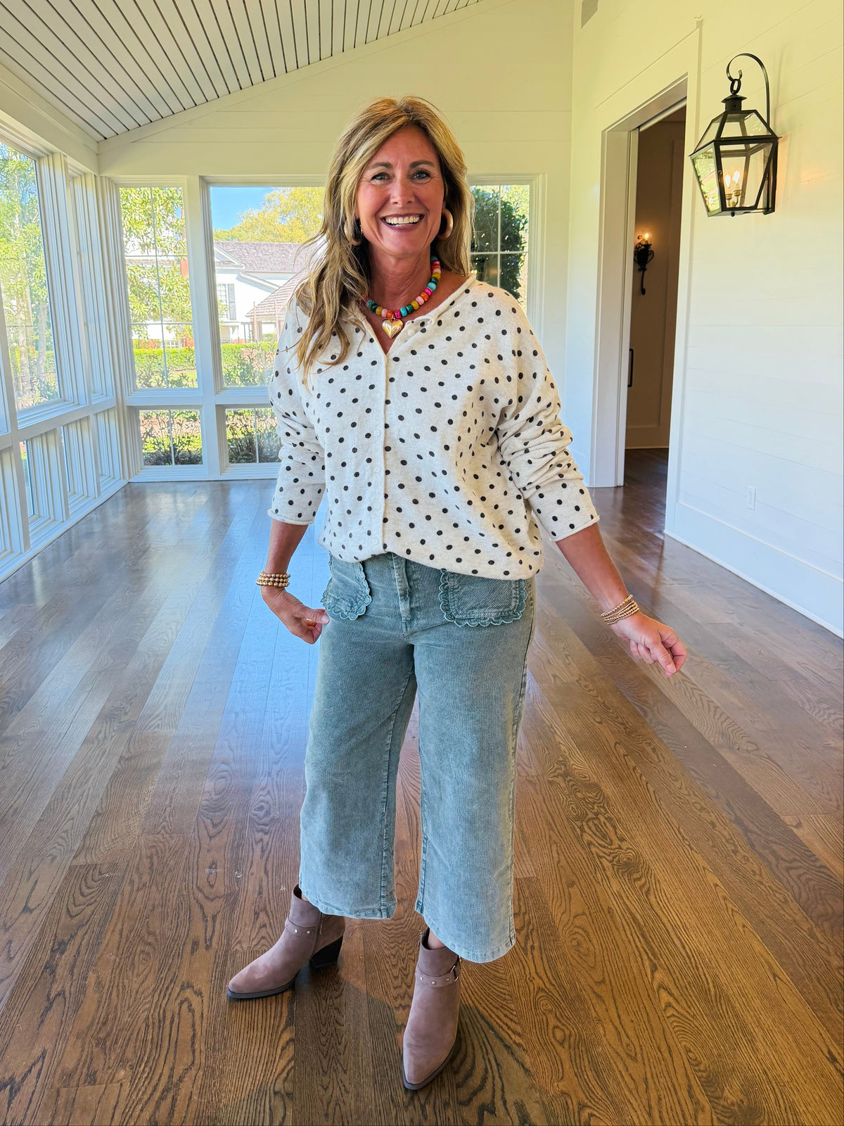 Kelly wearing the Betsy oatmeal polka dot button-front cardigan with light blue cropped pants and taupe ankle boots.