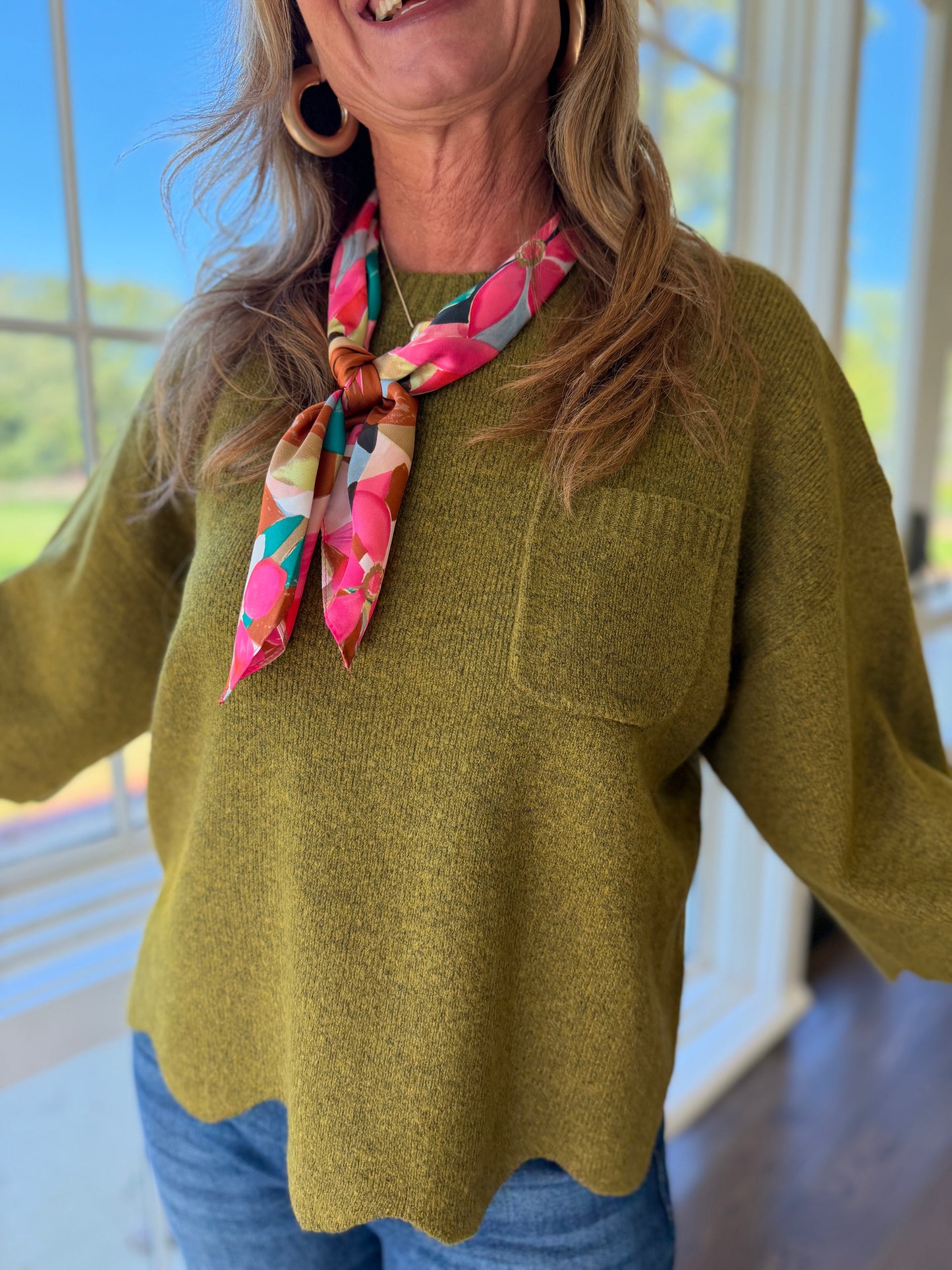 Close-up of the Briar olive knit top showing its crew neckline, patch pocket and heathered texture.