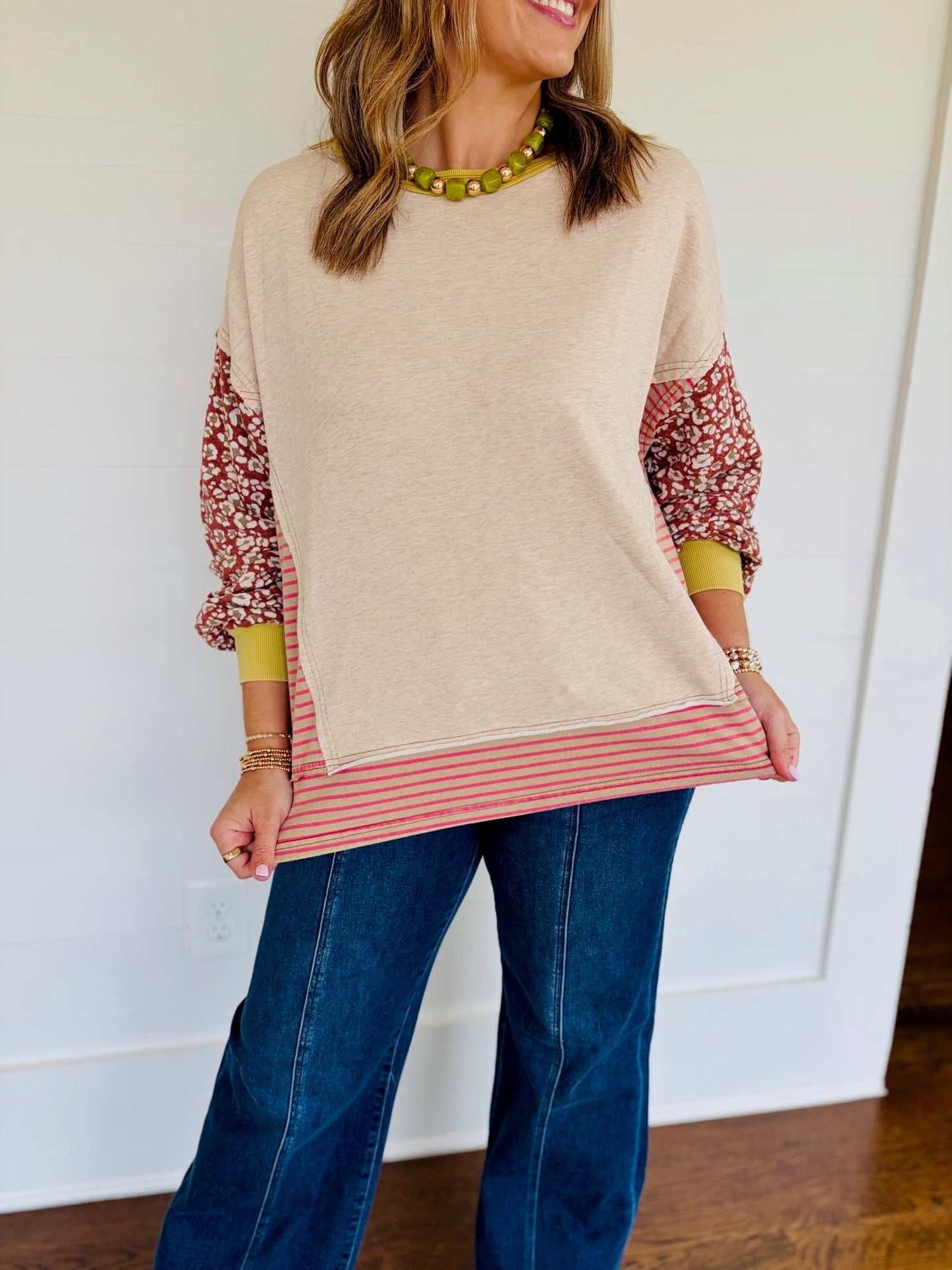 Jessica wearing the Delaney oatmeal mixed-print patchwork sweatshirt with wide-leg jeans