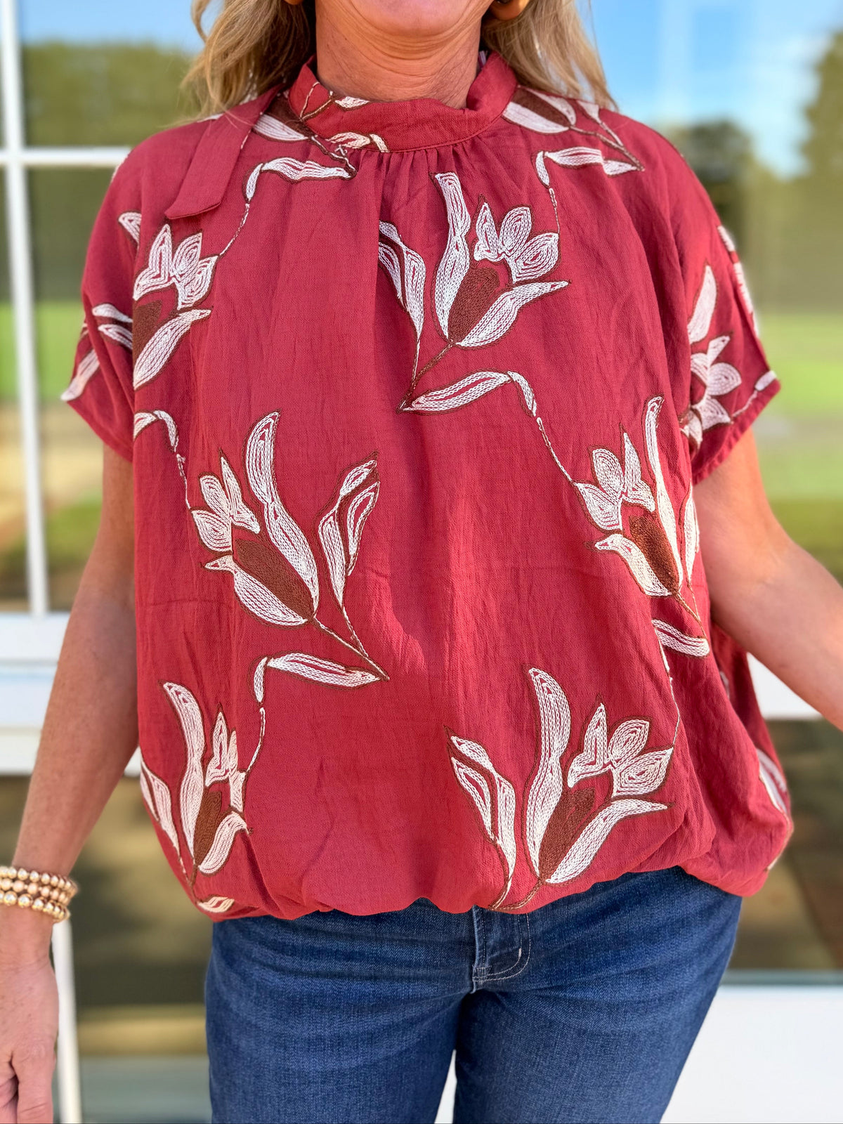 Close-up of the Delilah auburn floral blouse showing its gathered high neckline, oversized floral print and relaxed sleeves.