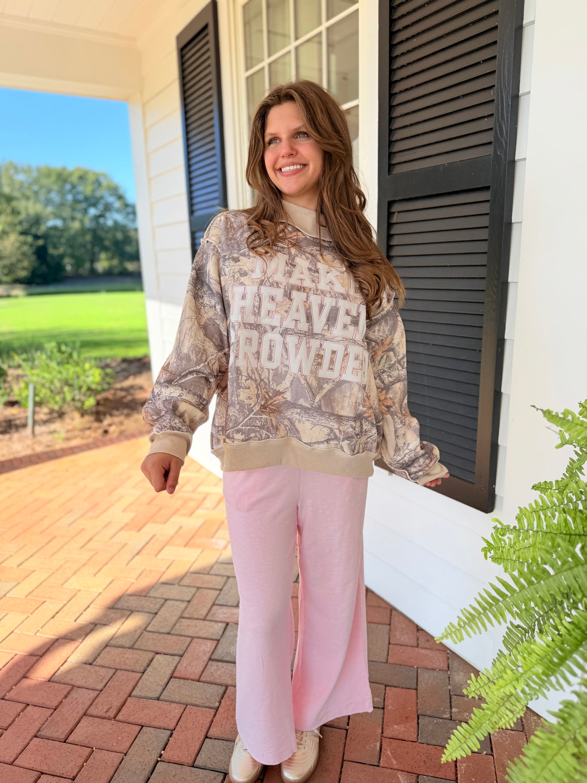 Gade wearing the Della soft pink wide-leg lounge pants with a neutral graphic sweatshirt and beige shoes.
