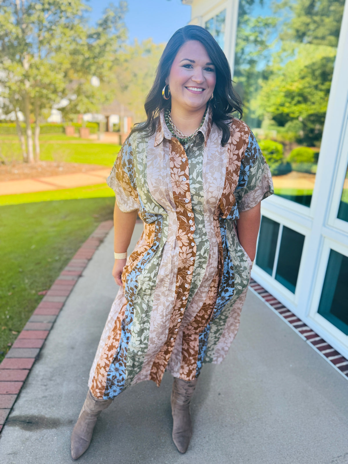 Alex wearing the Faith Fall Medley floral maxi dress in extended sizing with short sleeves, a defined waist and taupe boots.