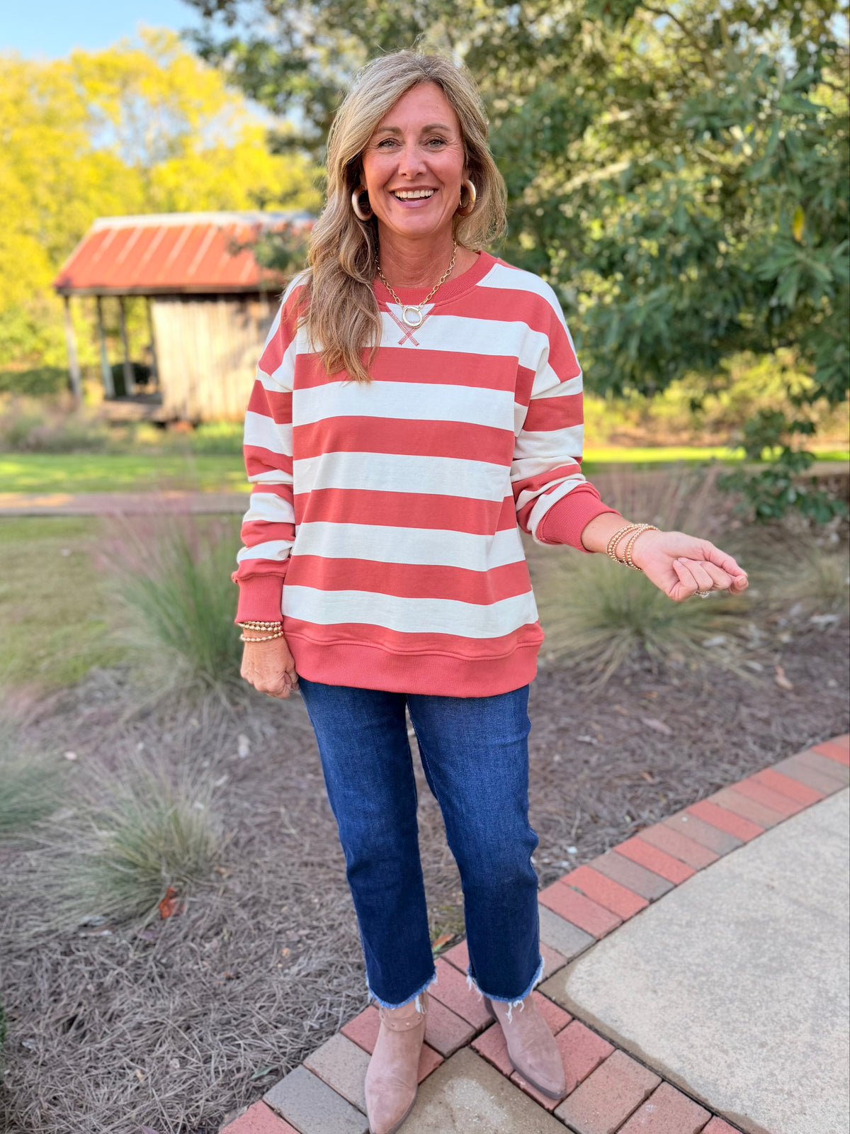 Kelly wearing the Finley vintage orange and ecru striped sweatshirt with cropped jeans and neutral ankle boots.