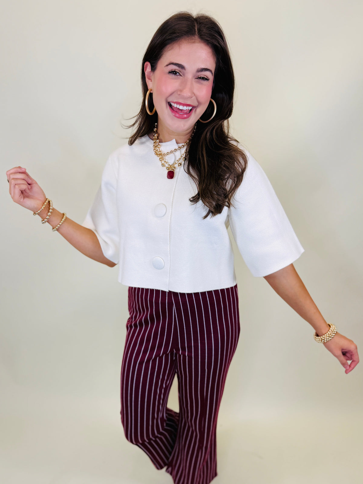 Lacey wearing the Georgia cream covered-button cropped jacket with burgundy striped pants.