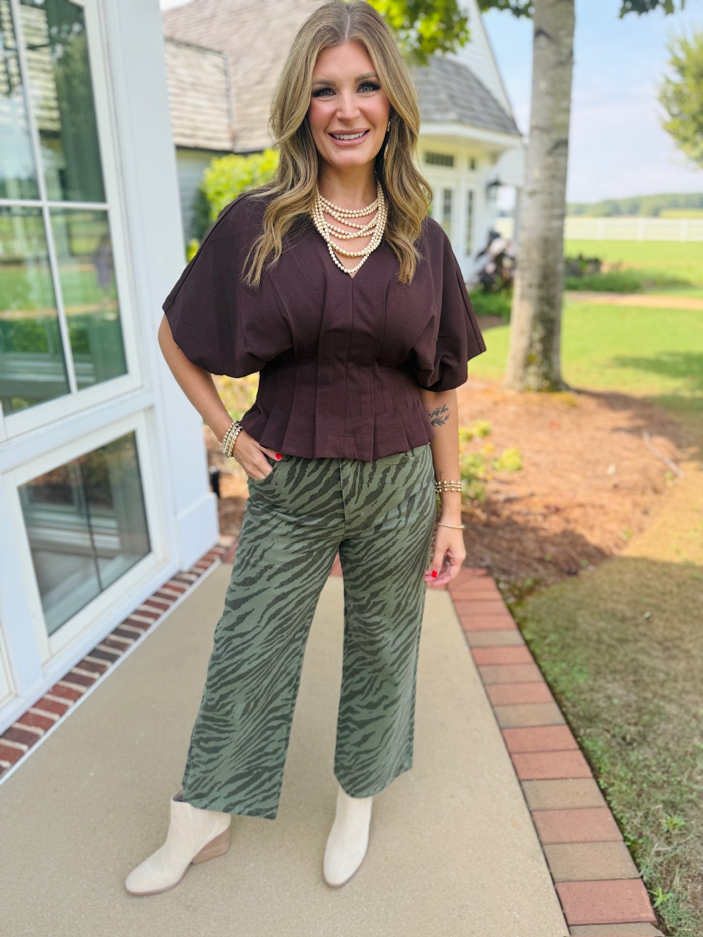 Close-up of the Josie olive zebra-print cropped wide-leg pants styled with cream ankle boots