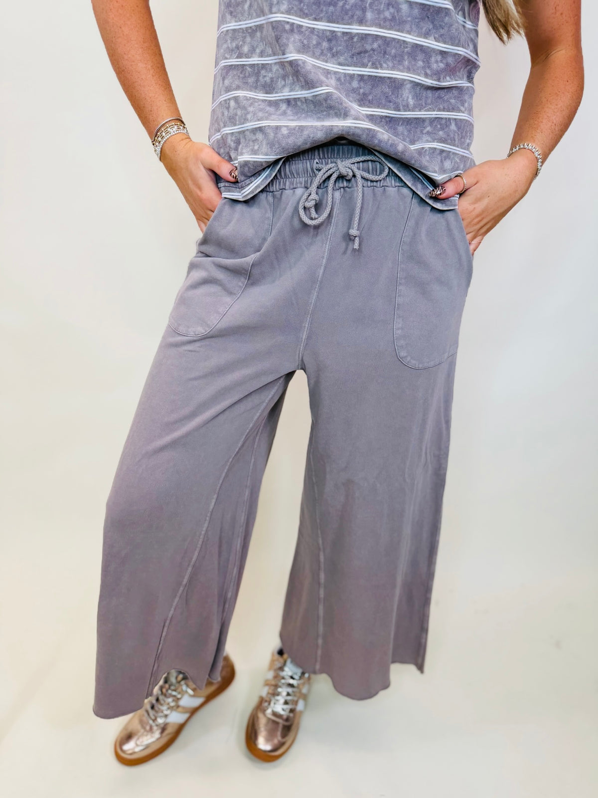 Karter cropped wide-leg lounge pants with a drawstring waist, styled with a striped tee and metallic sneakers.