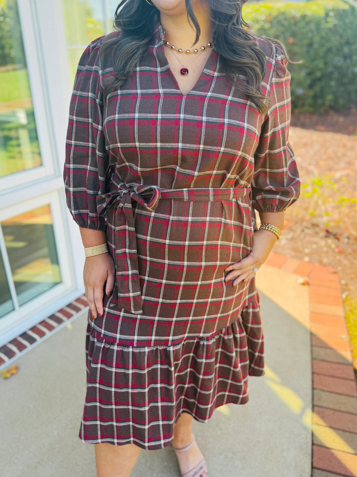 Closer view of the Kelsey brown plaid midi dress showing its V-neckline, plaid pattern and self-tie waist belt.
