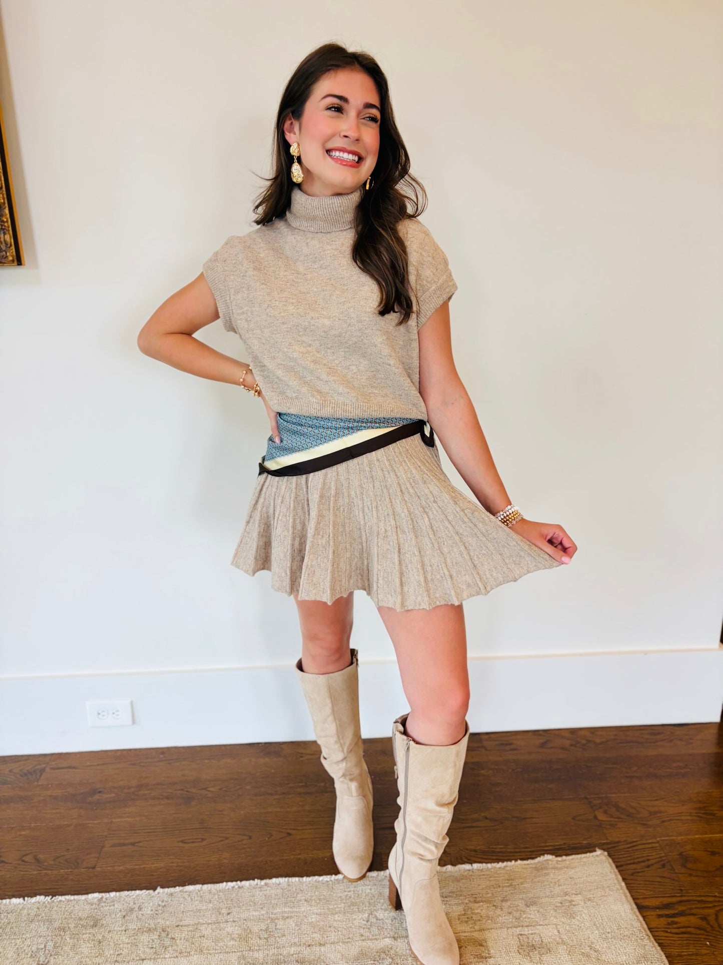 Lacey wearing the dark taupe knit top and pleated mini skirt set with striped trim and knee-high boots