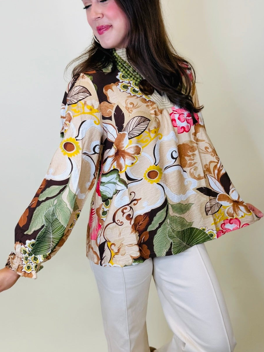 Side view of the Leilani beige botanical print blouse showing its contrast neckline, flowy fit and balloon sleeve.