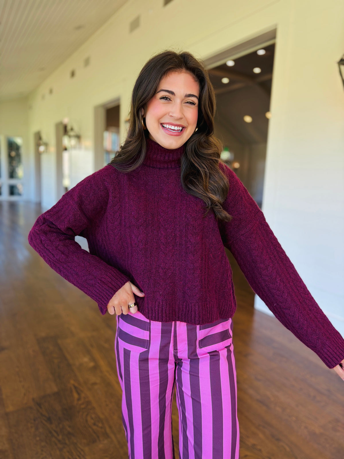 Closer view of the Lorelai dark cherry sweater showing its cable-knit texture, ribbed turtleneck, cuffs and hem.