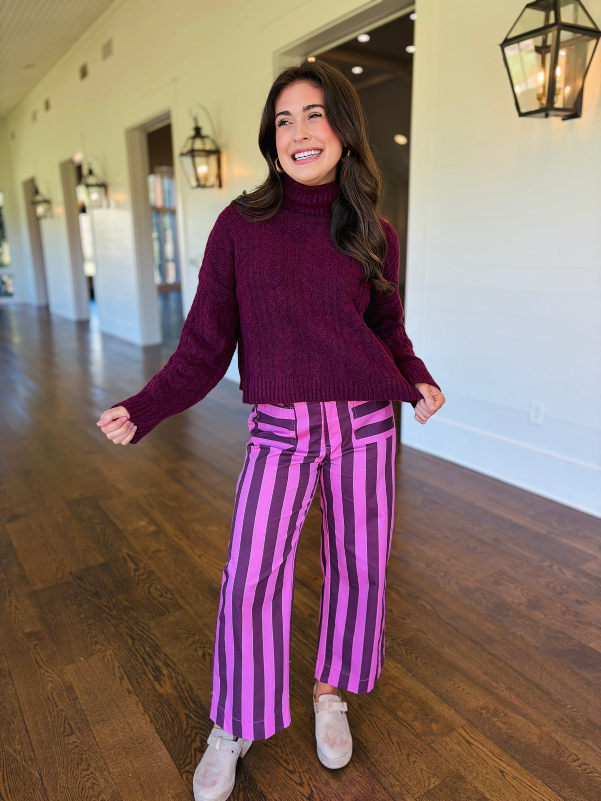 Lacey wearing the Quinn burgundy stripe wide-leg pants with a dark cherry sweater and neutral shoes.