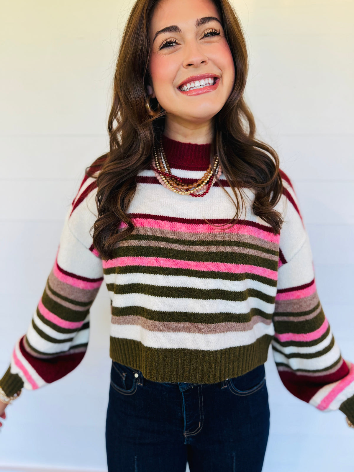Lacey wearing the Maisyn wine multi striped cropped sweater with dark blue jeans.