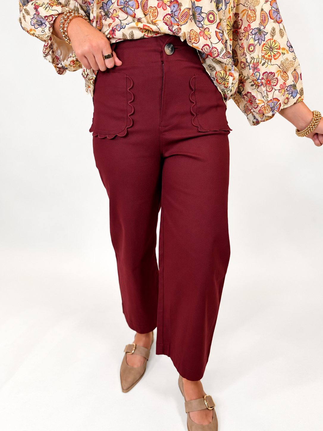 Close-up of the Maren burgundy cropped pants featuring scalloped front patch pockets and a button closure.
