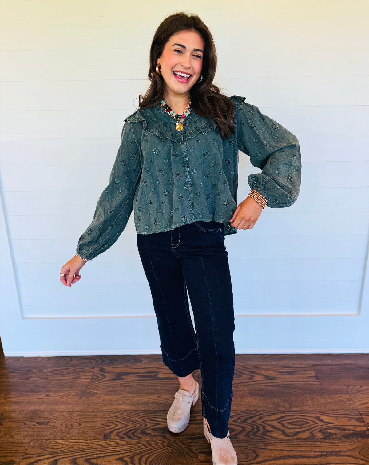Lacey wearing the Mariana moss eyelet ruffle blouse with dark cropped jeans and neutral shoes.