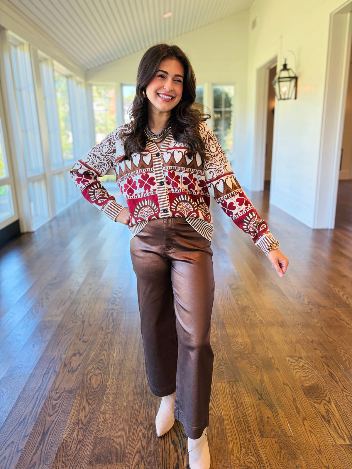 Lacey wearing the Mckenna cream heart print cardigan with brown trousers and neutral ankle boots.