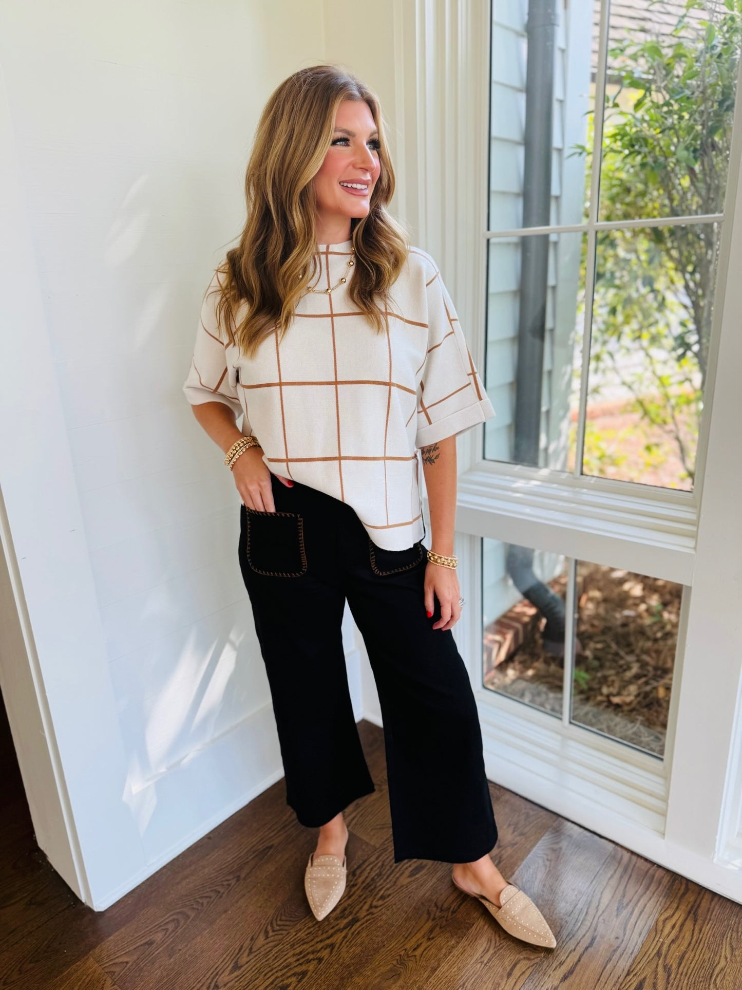 Morgan wearing the Melany black cropped wide-leg pants with tan contrast-stitch pockets and a cream windowpane top