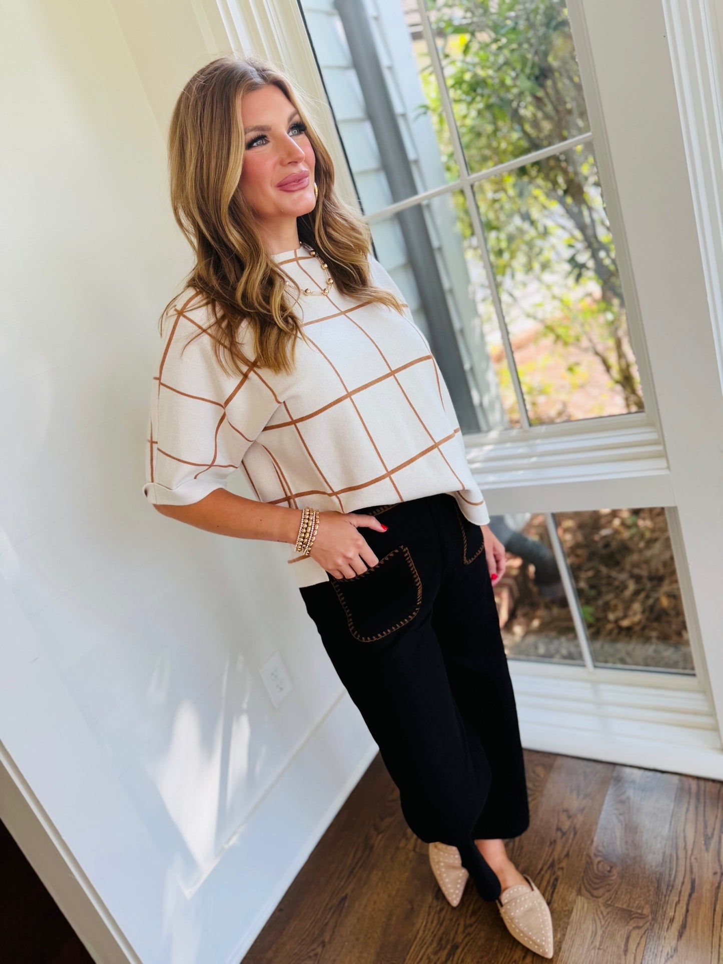 Full-length view of Morgan wearing the Melany black contrast-stitch cropped wide-leg pants with neutral flats