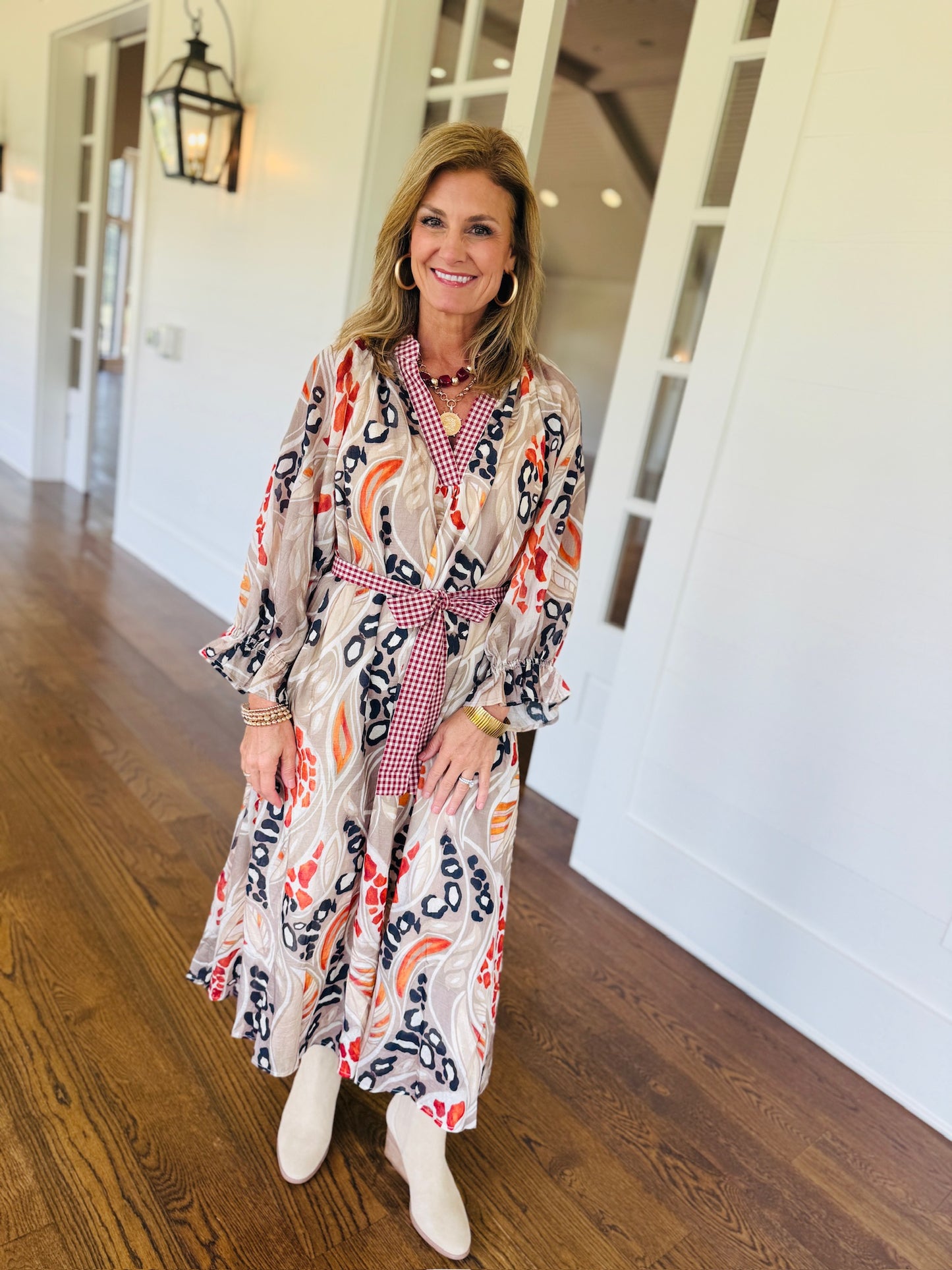 Ginny wearing the Melody mocha abstract floral maxi dress with neutral boots