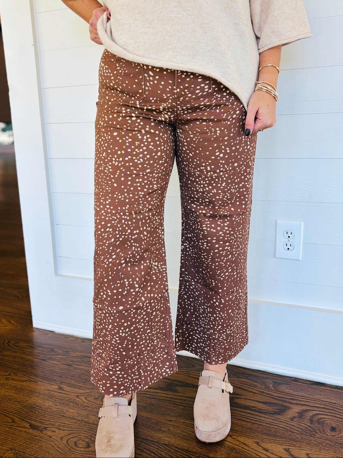 Close-up of the Mila brown speckled wide-leg pants showing their high-rise waist, cream print and cropped silhouette.