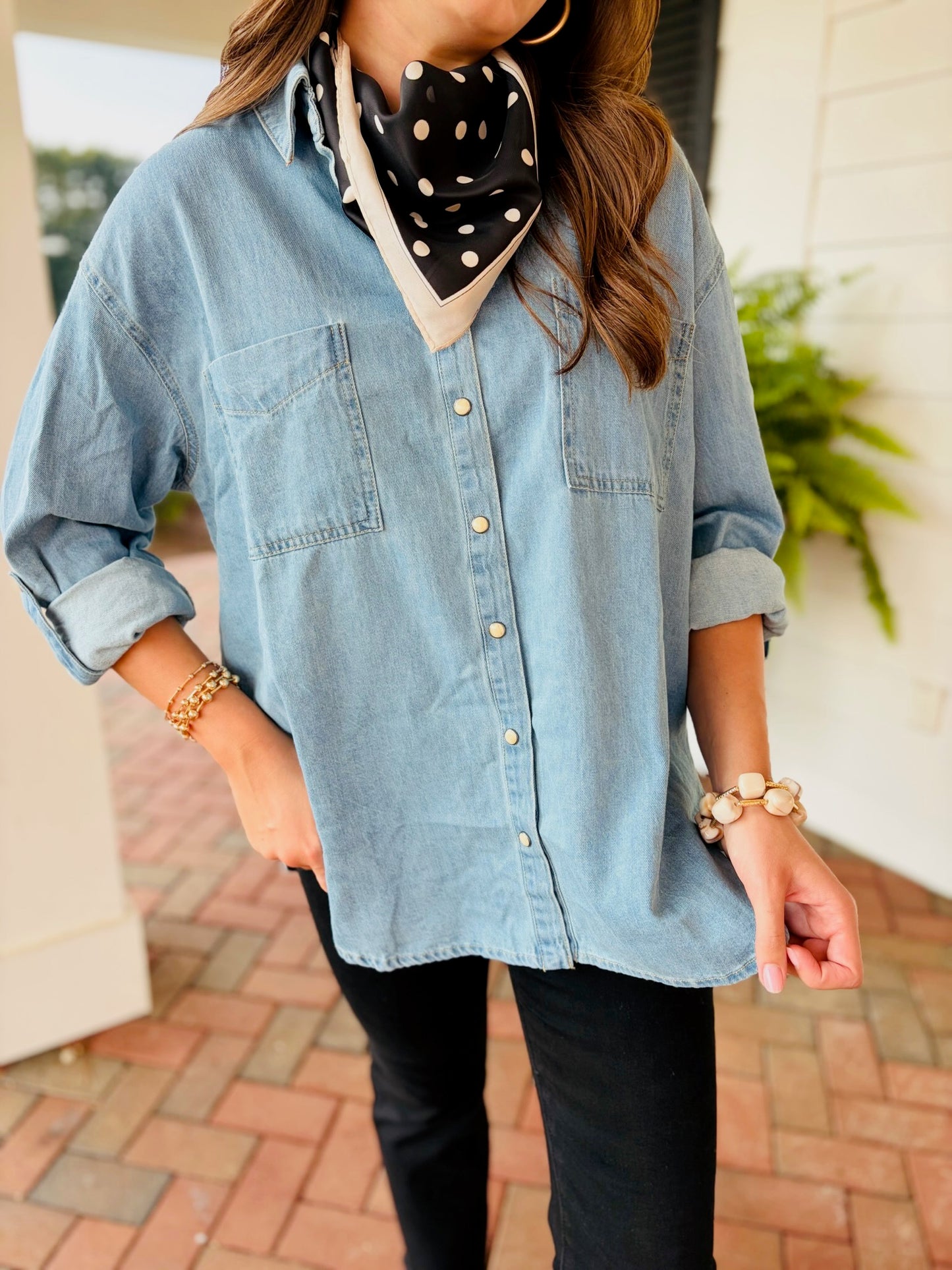 Front detail of Lacey wearing the Miley light-wash denim button-up shirt with rolled sleeves and chest pockets