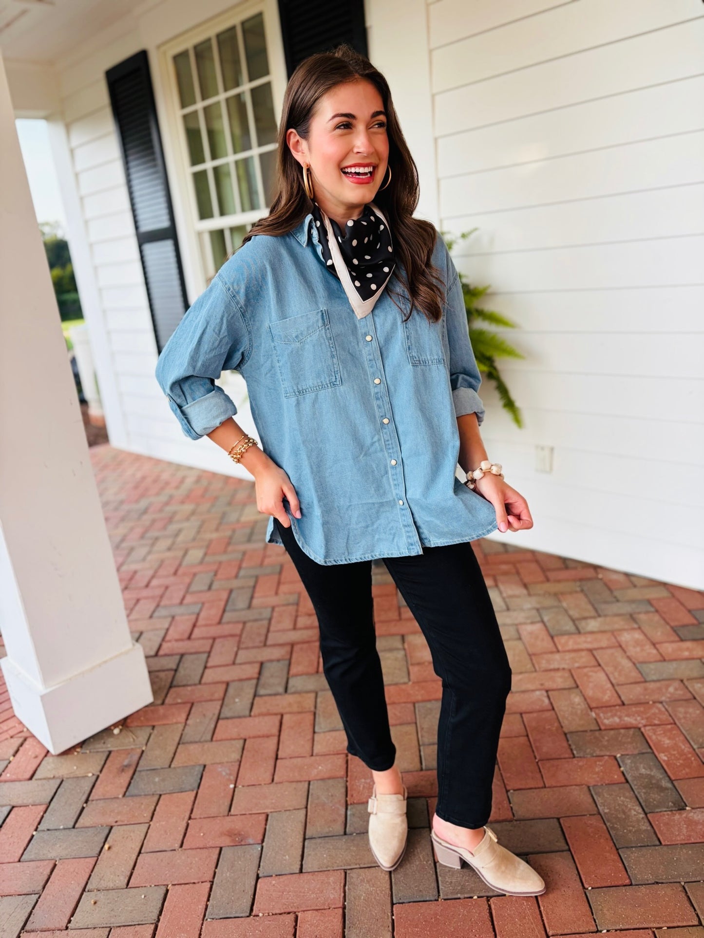 Lacey wearing the Miley light-wash oversized denim button-up shirt with black pants and a polka-dot scarf