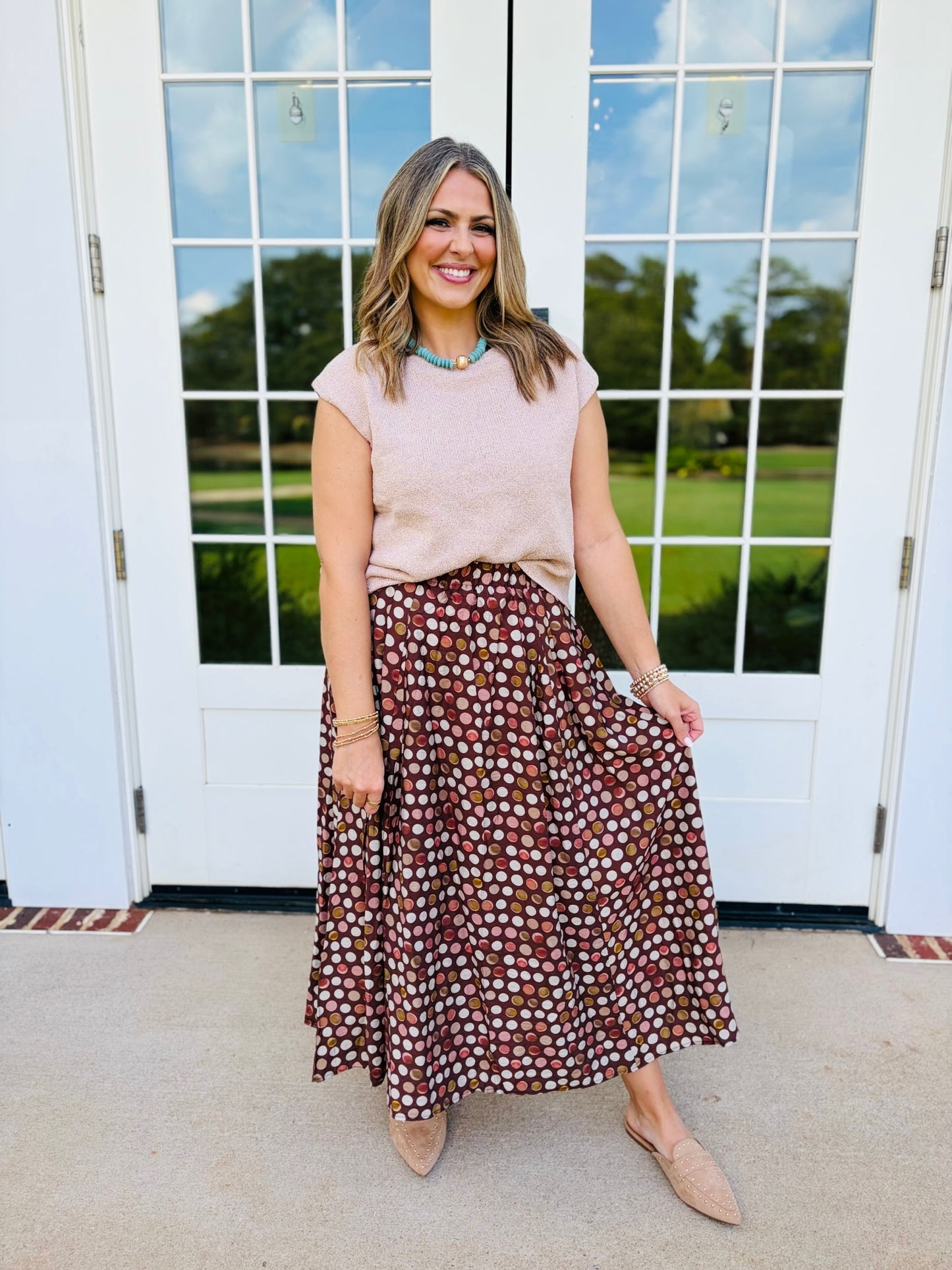 Jessica wearing the Millie brown multicolor polka-dot maxi skirt with a blush short-sleeve top and neutral heels