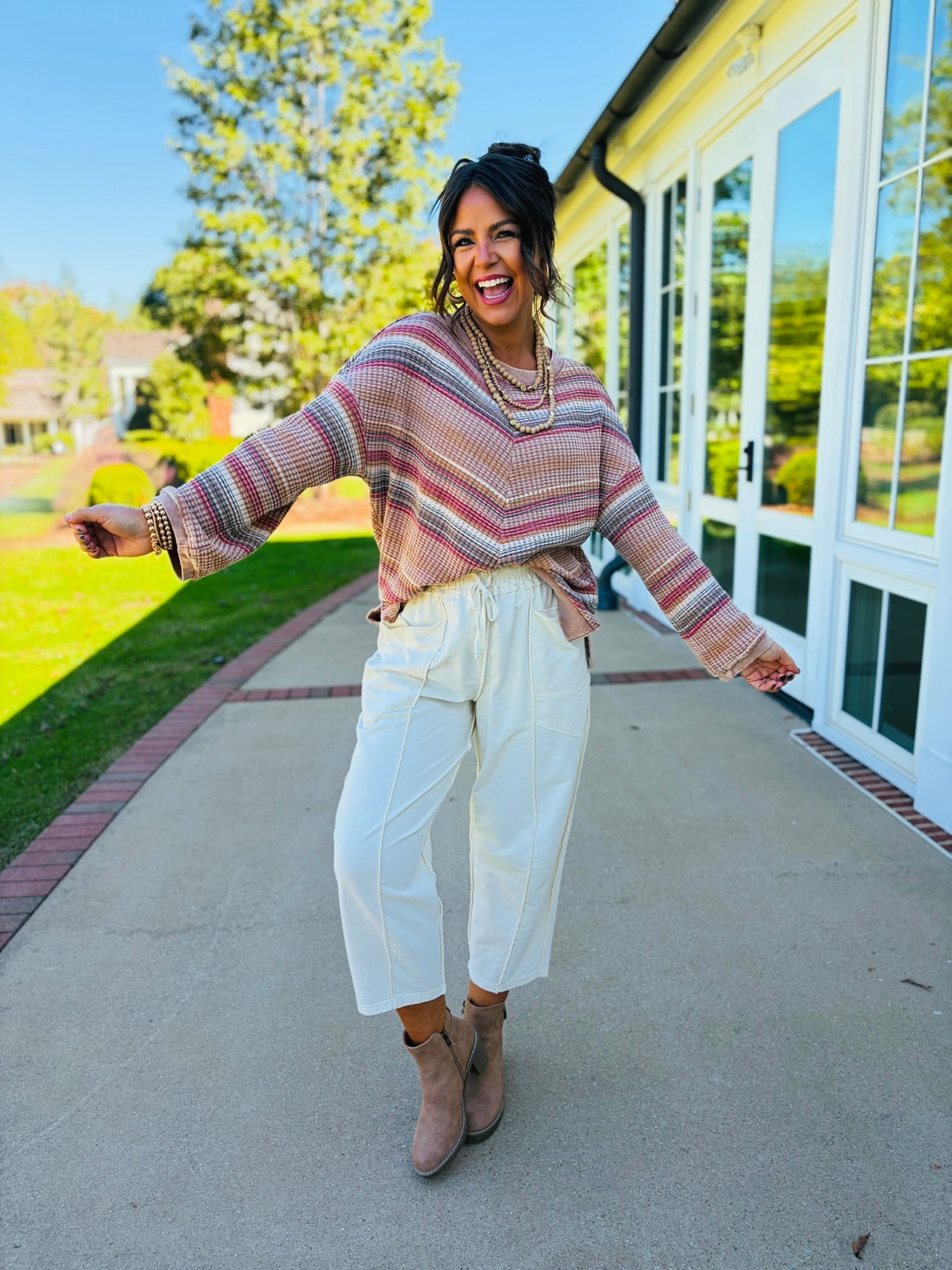 Brooke wearing the Nadia mocha striped waffle-knit top with cream drawstring pants and taupe ankle boots.