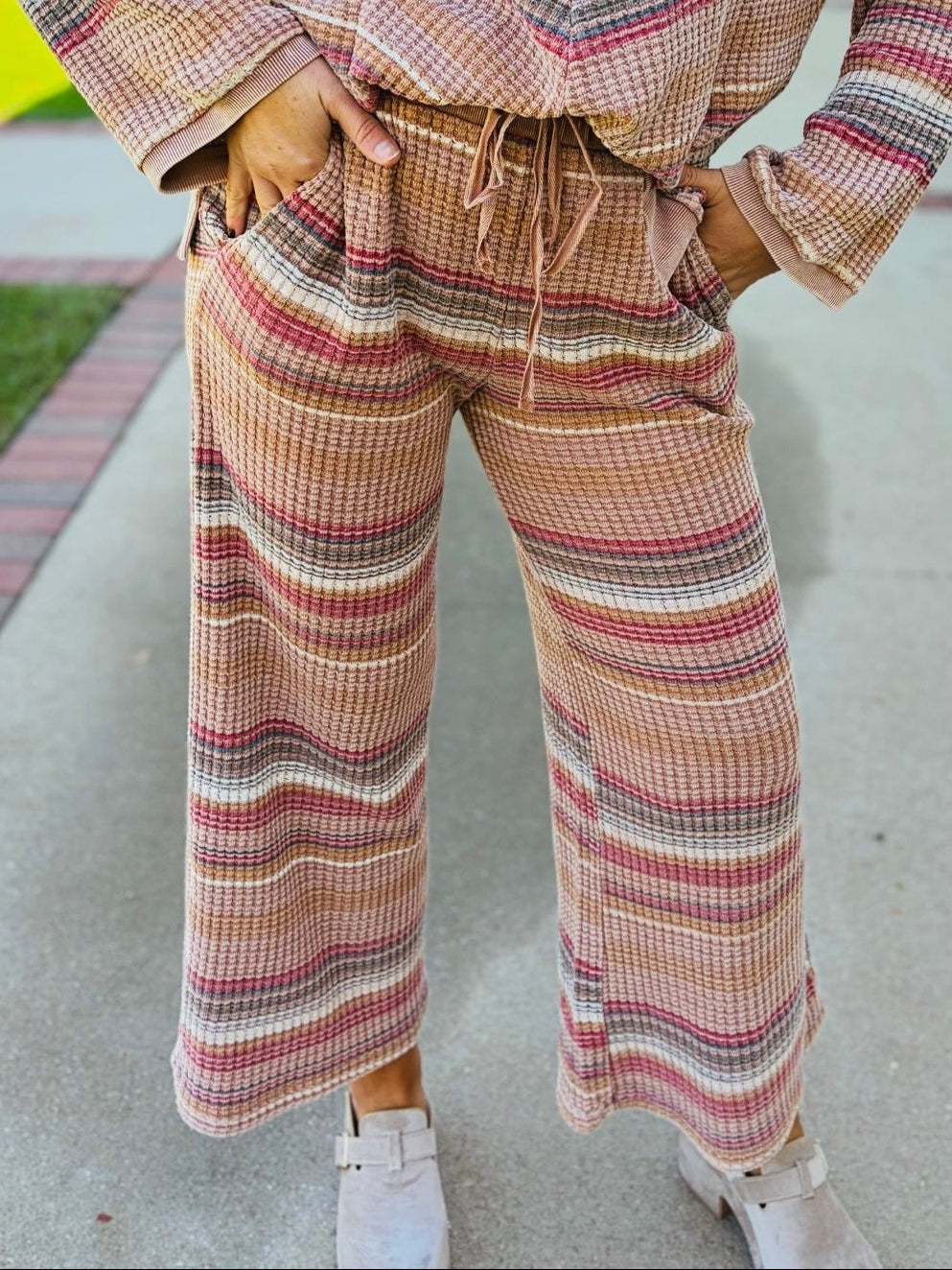 Close-up of the Nadia mocha striped waffle-knit pants showing their drawstring waistband, front pockets and wide-leg silhouette.