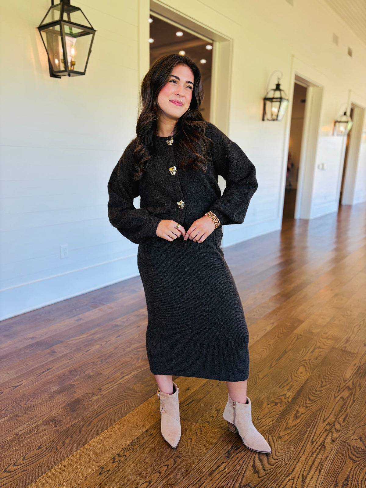Lacey wearing the Noelle charcoal brown button cardigan with its coordinating knit midi skirt, sold separately.