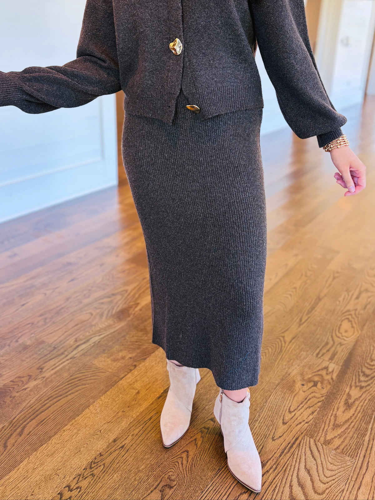 Closer view of the Noelle charcoal brown knit midi skirt showing its high-rise waist, ribbed texture and straight silhouette.