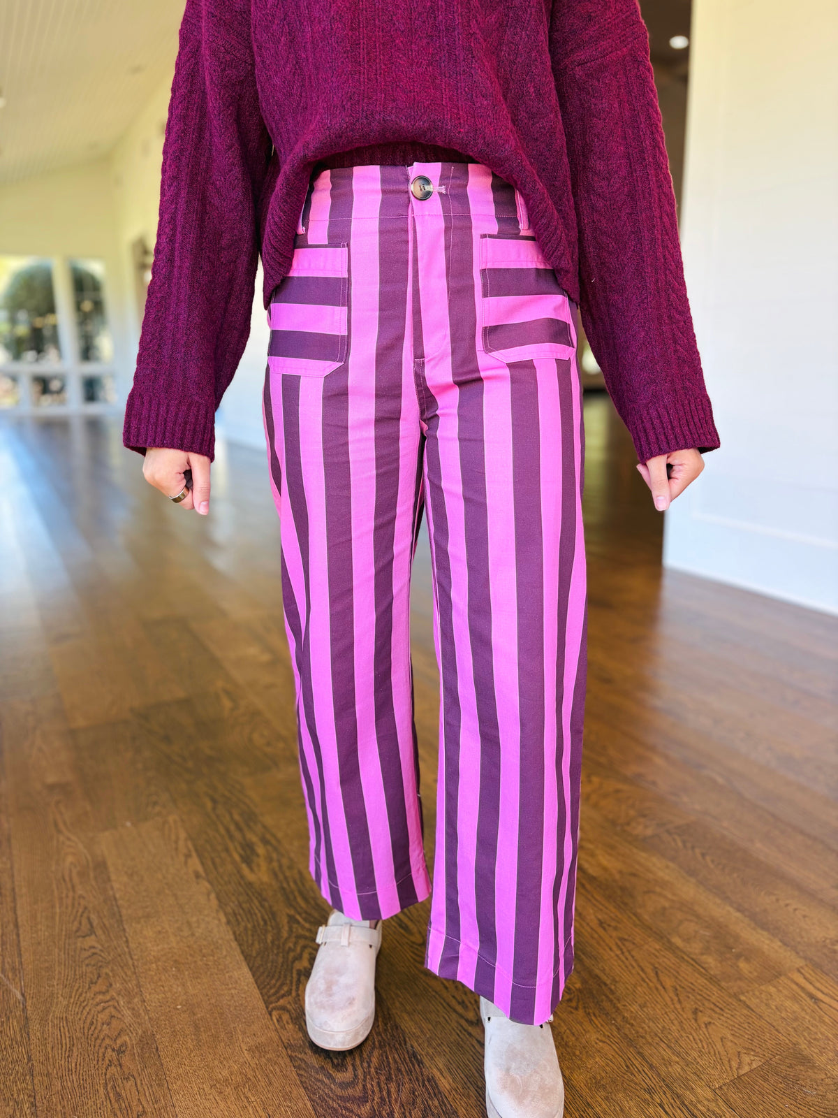 Closer front view of the Quinn burgundy stripe wide-leg pants showing their high-rise waist, button closure and patch pockets.