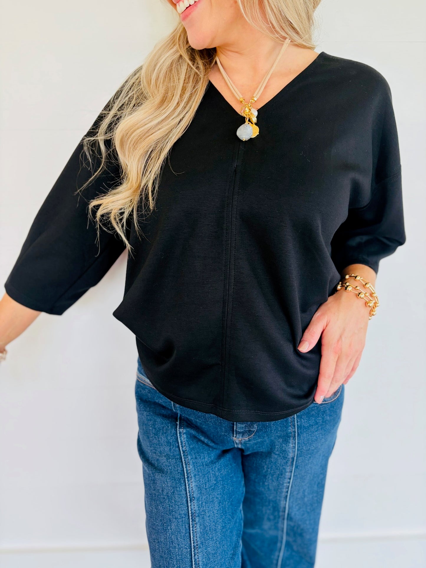 Close-up of Lorin wearing the Rosalie black V-neck top with three-quarter sleeves