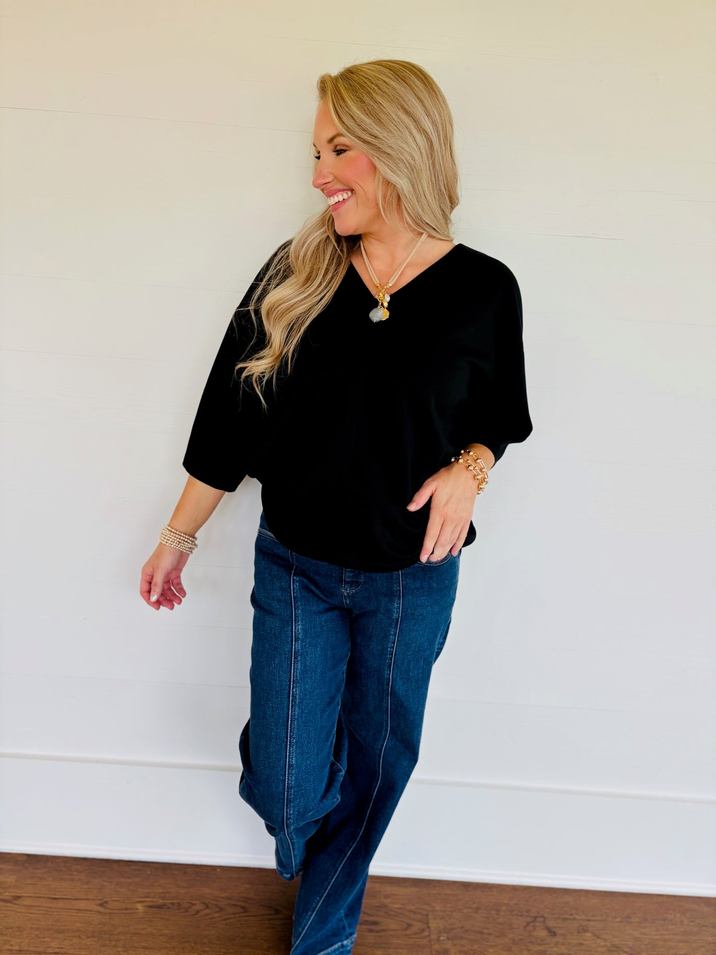 Lorin wearing the Rosalie black V-neck top with three-quarter sleeves and blue jeans