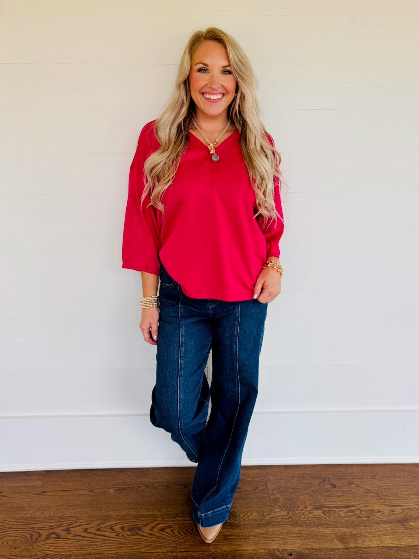 Lorin wearing the Rosalie magenta V-neck three-quarter-sleeve top with dark-wash wide-leg jeans