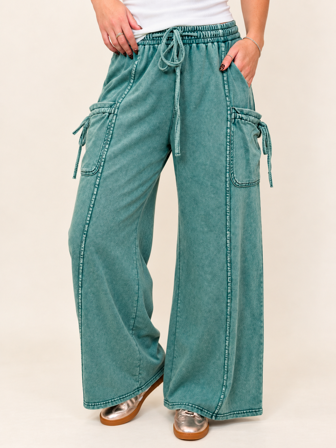 Close-up of the Saylor pine green cargo pants showing the elastic drawstring waist, patch pockets and tie details