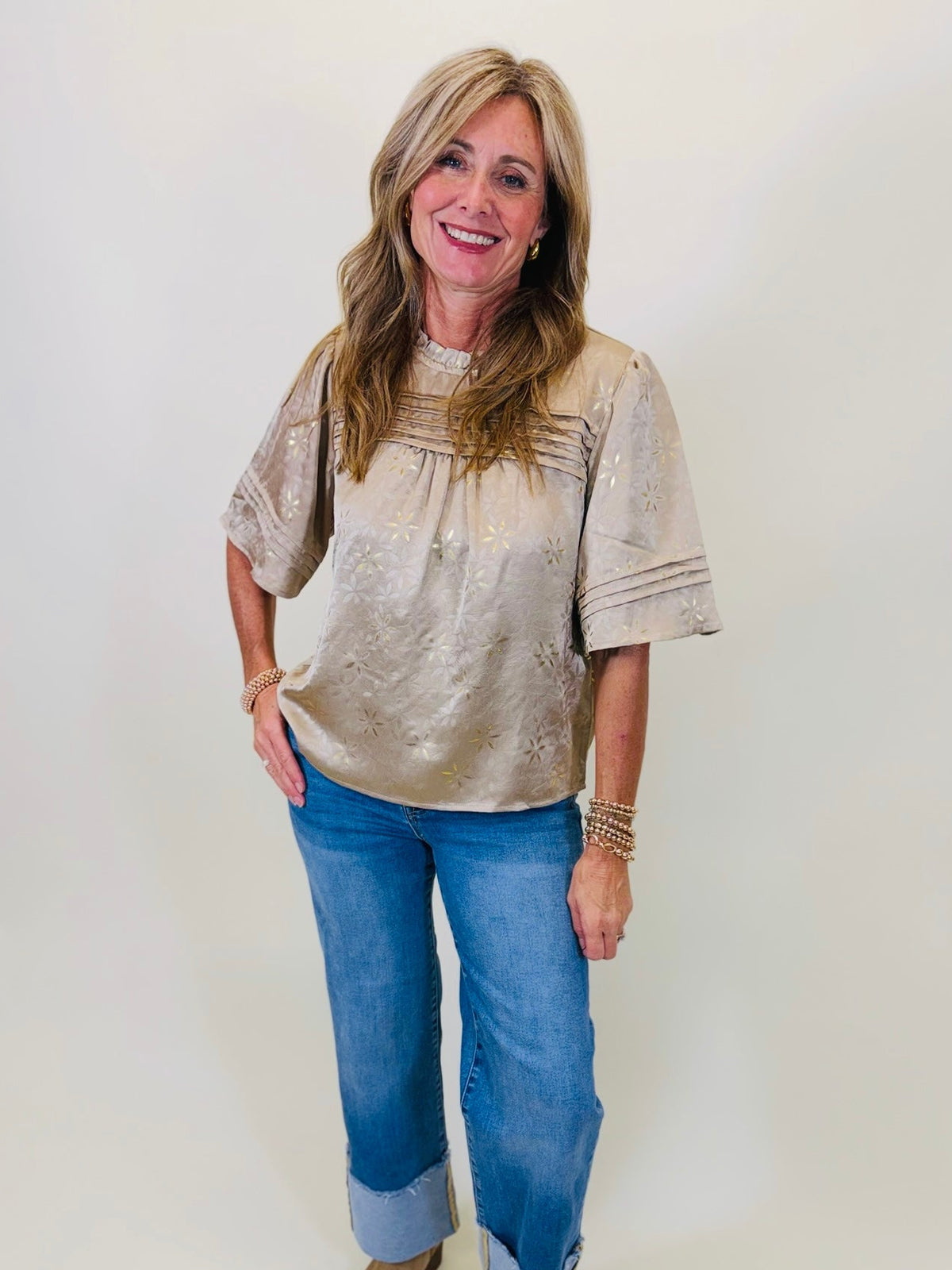 Kelly wearing the Serenity tan floral pintuck blouse with cuffed blue jeans.