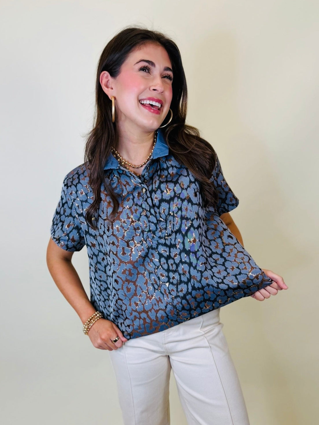 Lacey wearing the Skye blue metallic leopard print collared blouse with white pants.