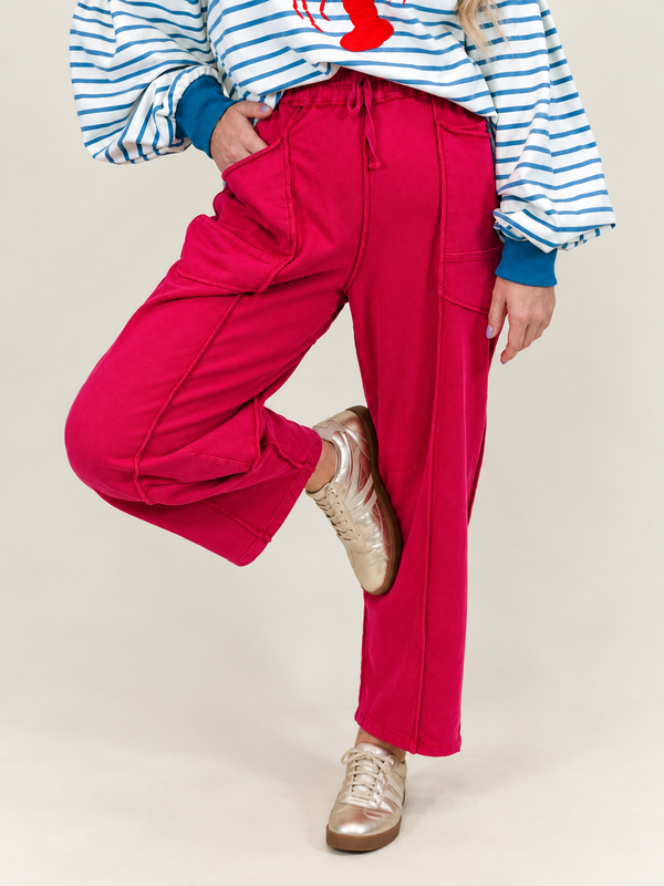 Close-up view of the drawstring waist, utility pockets, and center seam piping on The Blair red cotton pants.