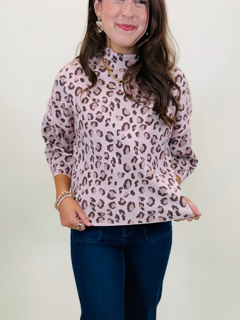 Close-up view of the mock neckline and blush pink leopard knit fabric on The Penelope top.