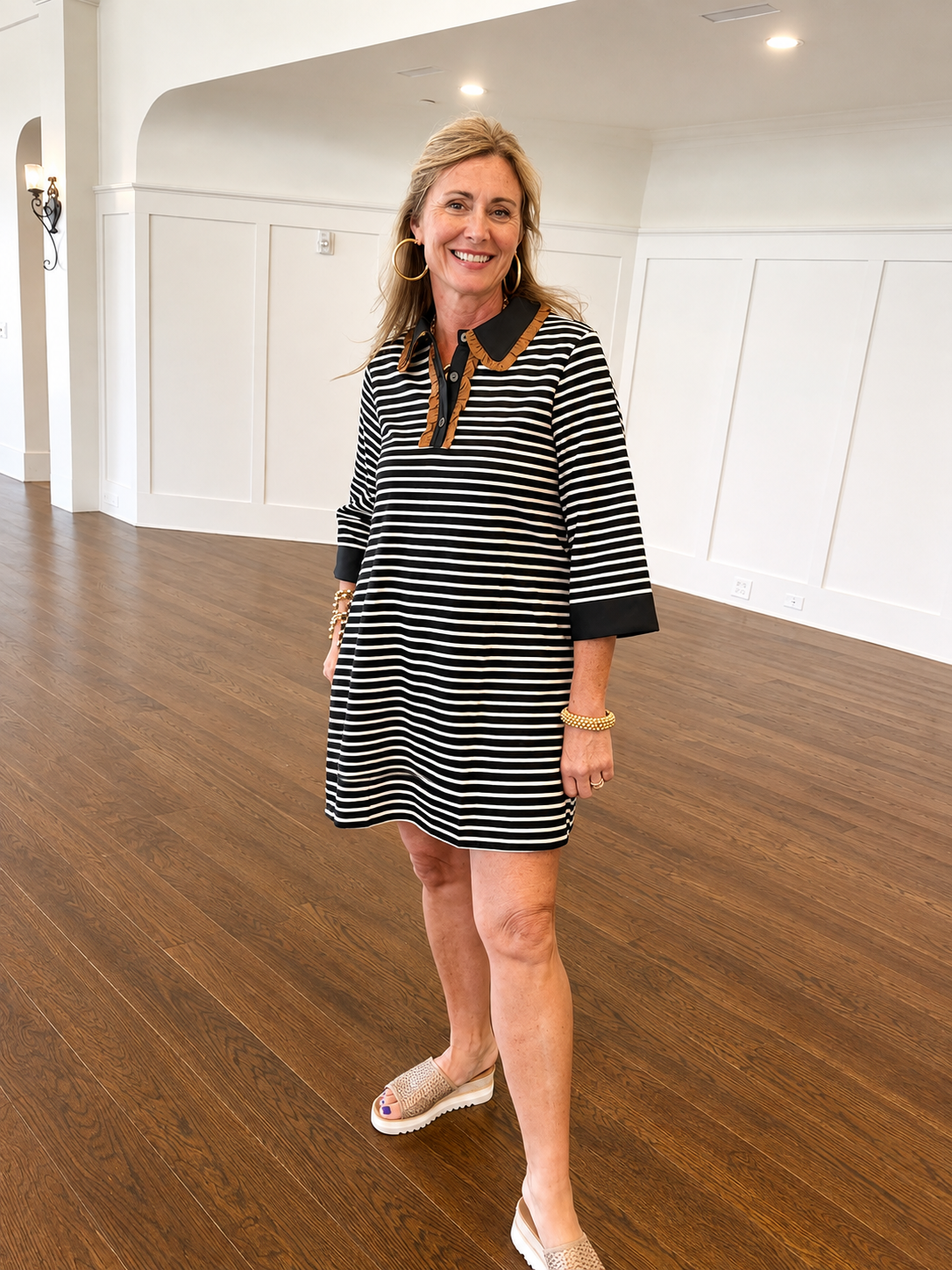 Kelly wearing the Trinity black and white striped shift dress with a brown contrast collar and sandals