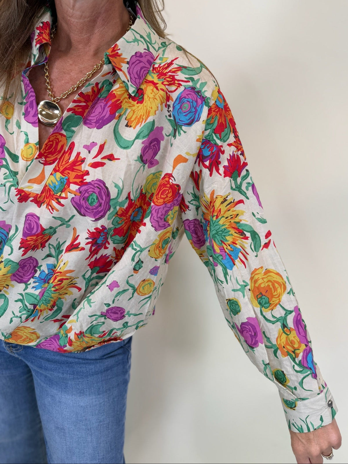 Close-up of the Willow blouse showing its vibrant multicolor floral print, collar and buttoned cuff.